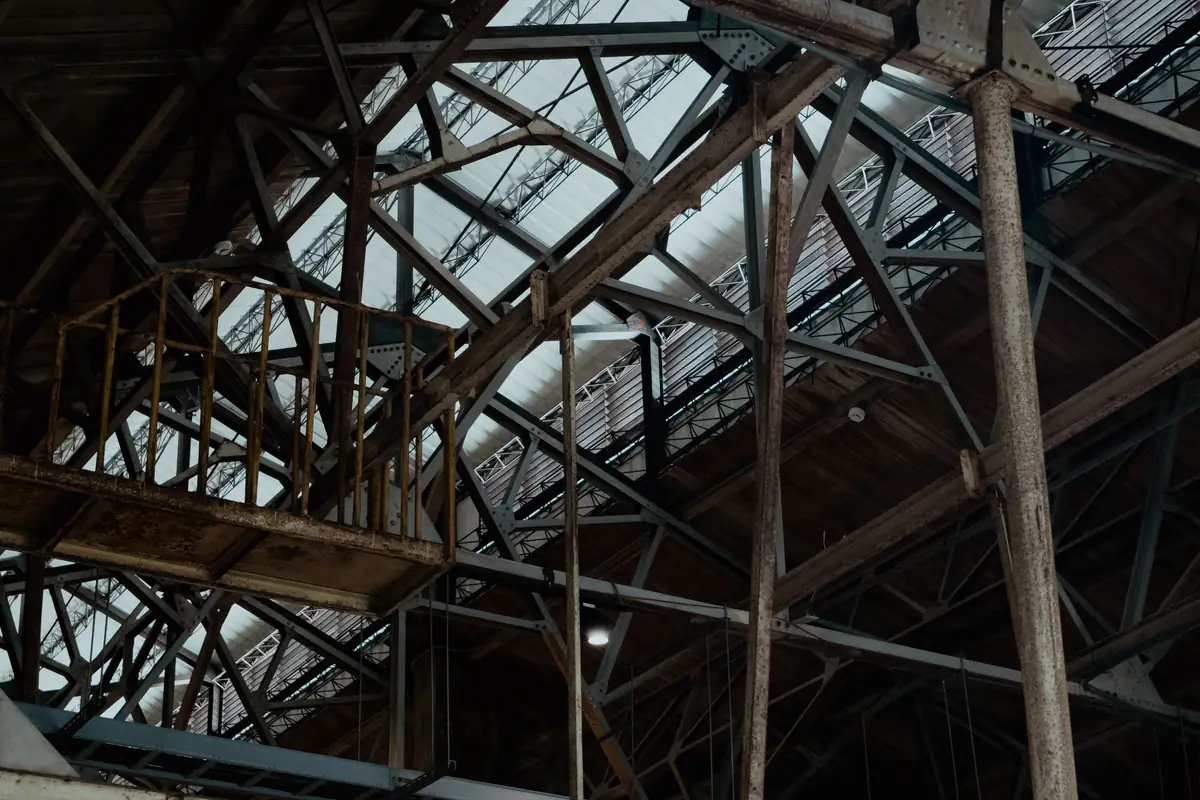 Estrutura treliçada de aço no interior de um galpão industrial