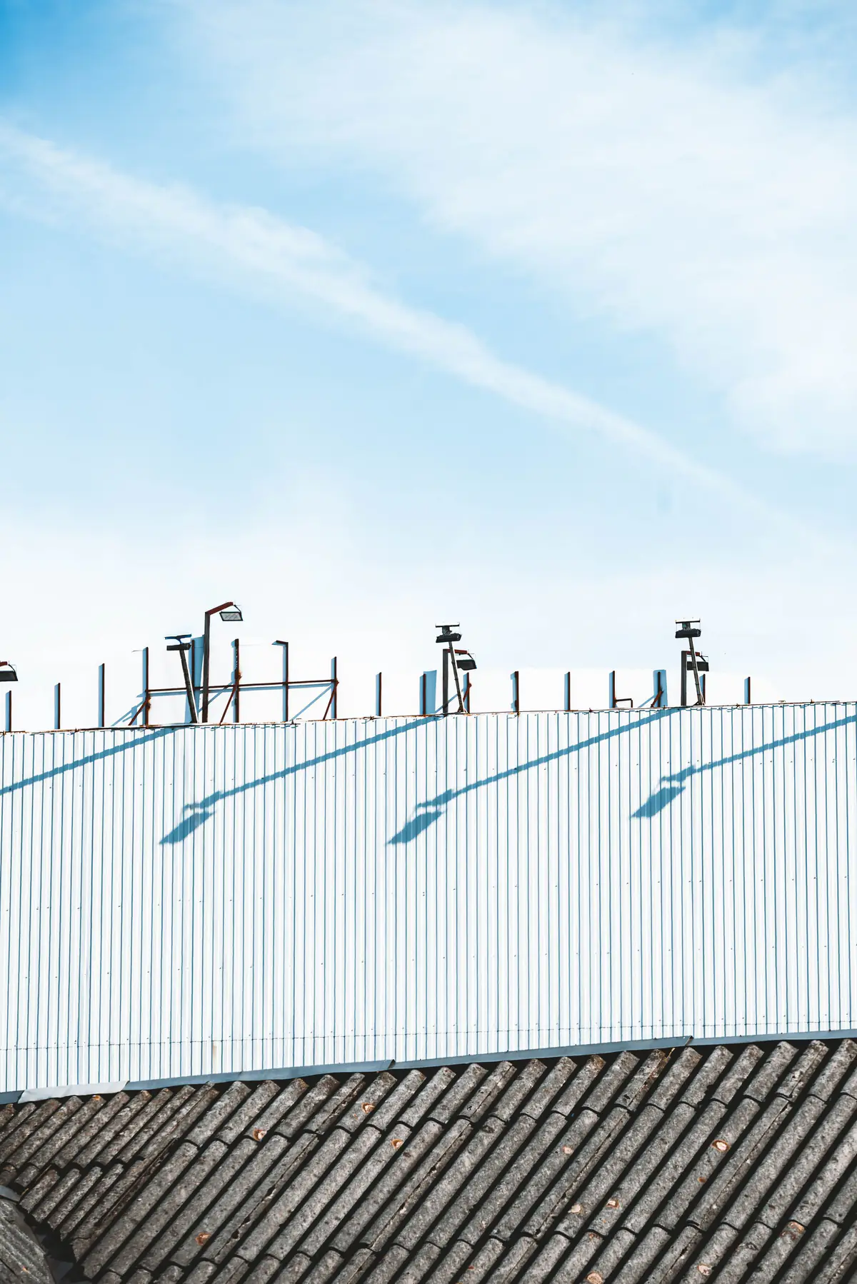Telhado industrial de telhas metálicas claras com projeção de sombras